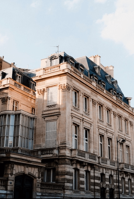 Haussmann-style French limestone apartment facade with mansard roof